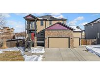 Two-story house with stone accents, a two-car garage, and a balcony at 9066 Sandpiper Dr, Frederick, CO 80504