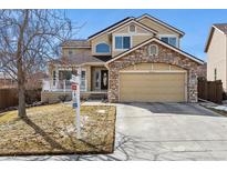 Two-story house with stone accents, attached garage, and manicured lawn at 8656 Aberdeen Cir, Highlands Ranch, CO 80130