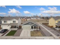 Charming single-Gathering home features a well-maintained lawn and an attached two-car garage at 47341 Lily Ave, Bennett, CO 80102