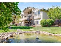 Beautiful home exterior featuring a tranquil pond, spiral staircase, and lush green landscaping at 12 Canon Cir, Greenwood Village, CO 80111