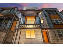 Modern three-story townhome with a metal balcony and a combination of siding and stone accents at 2347 Kite Route Ln, Superior, CO 80027
