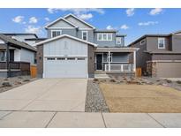 Two-story home featuring a two-car garage and a charming front porch at 1349 Brookfield Pl, Erie, CO 80026