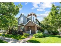 Charming two-story home featuring a turret, brick accents, balcony, and a well-manicured front yard at 7746 E Severn Pl, Denver, CO 80230