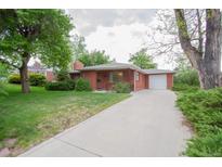 Charming single-story red brick home with a long driveway, lush green lawn, and mature trees at 3222 Fenton St, Wheat Ridge, CO 80212