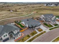 Stunning aerial view of a modern home with a fenced yard and walking trails in the distance at 14341 Beebalm Loop, Parker, CO 80134