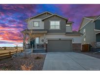 Charming two-story home with landscaped yard, two car garage and covered front porch with beautiful sunset at 610 Mosquito St, Elizabeth, CO 80107