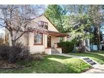 Charming brick home with a cozy front porch and a well-manicured lawn with mature trees at 461 N Marion St, Denver, CO 80218
