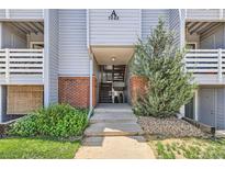 Inviting condo building entrance featuring brick accents and well-maintained landscaping at 7665 E Eastman Ave # 106A, Denver, CO 80231