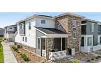 Attractive townhome with stone accents, neutral siding, and inviting front porch at 16351 Askins Loop, Parker, CO 80134