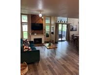 Inviting living room features a fireplace, wood accent wall, and sliding glass doors to the outside at 2773 S Lansing Way, Aurora, CO 80014