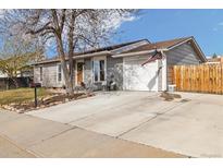 Charming gray single-story home with a well-maintained front yard, concrete driveway, and an attached garage at 1049 Lilac St, Broomfield, CO 80020