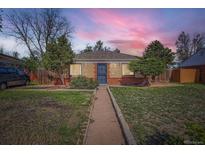 Charming brick home featuring a well-maintained lawn and walkway leading to the front door at 2220 Quebec St, Denver, CO 80207