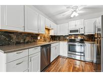 Updated kitchen features stainless appliances, wood floor, and white cabinets at 750 S Alton Way # 9B, Denver, CO 80247