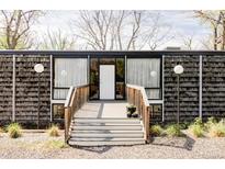 Striking modern home featuring a unique facade with inviting wood deck, adding character to the exterior at 7170 W 8Th Pl, Lakewood, CO 80214
