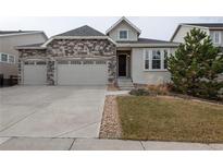 Charming home featuring a stone facade, attached two-car garage, and well-manicured front yard at 8791 Culebra Ct, Arvada, CO 80007