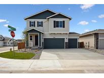Charming two-story home showcasing a three-car garage and well-manicured landscaping with a spacious driveway at 45952 Gentry Ave, Bennett, CO 80102