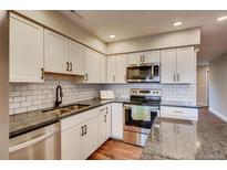 Bright kitchen featuring white cabinets, stainless steel appliances, and stylish subway tile backsplash at 7110 S Gaylord St # L7, Centennial, CO 80122