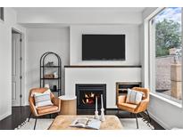 Cozy living room with a sleek fireplace, modern furniture, and abundant natural light from a large window at 3131 Vallejo St, Denver, CO 80211