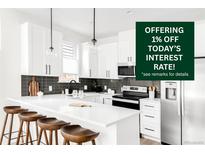 Modern kitchen boasts white cabinetry, subway tile backsplash, and a sleek island with bar seating at 3955 W 13Th Ave, Denver, CO 80204