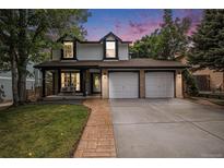 Charming two-story home with a well-manicured lawn and attached two car garage at 11022 Trailrider Pass, Littleton, CO 80127
