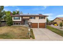 Charming two-story home with an attached two-car garage and solar panels on the roof at 1261 Eagle St, Aurora, CO 80011