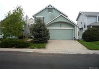 Charming home featuring light-green siding, an attached two-car garage, and a well-maintained front lawn at 21734 Farmingdale Ct, Parker, CO 80138
