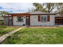 Charming single-story home featuring a pergola, fresh paint, neat landscaping, and sidewalk leading to the front door at 6220 W 11Th Pl, Lakewood, CO 80214