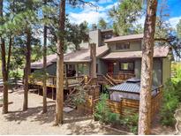 Charming multi-level home showcasing a wooden deck and gazebo surrounded by mature trees in a serene setting at 4515 Red Rock Dr, Larkspur, CO 80118