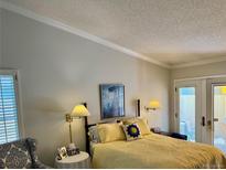 Cozy bedroom featuring a sunny yellow quilted bedspread and natural light from the door with access to the outdoors at 8040 E Dartmouth Ave # 16, Denver, CO 80231