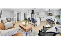 Open concept living room featuring a modern kitchen, dining area, and comfortable seating at 1173 Xenon St, Golden, CO 80401