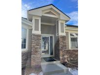 Inviting entryway with stone accents and a charming covered porch at 13739 Legend Trl # 102, Broomfield, CO 80023