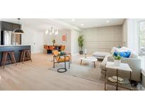 Open-concept living room features modern furnishings, light wood floors and dining area for seamless entertaining at 4682 Chatham St, Boulder, CO 80301