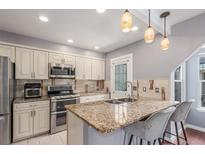 Bright kitchen with stainless steel appliances, granite countertops and breakfast bar seating for two at 8360 W 87Th Dr # D, Arvada, CO 80005