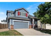 Charming two-story home with a gray exterior, red shutters, a well-manicured lawn, and an attached two-car garage at 4947 Stoneham Ave, Castle Rock, CO 80104