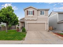 Charming two-story home with a well-maintained lawn, mature tree, and two car garage at 1179 S Alton Ct, Denver, CO 80247