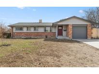 Charming single-story home featuring brick accents, a gray garage door, and a well-maintained front yard at 2572 Beech Ct, Golden, CO 80401
