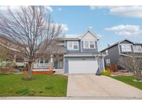 Charming two-story home with blue siding, attached two-car garage, and well-manicured front lawn at 10965 Dearborne Dr, Parker, CO 80134