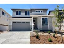 Two story home with gray stone accents, gray siding, large windows, a gray garage door, and landscaping at 455 S Salida St, Aurora, CO 80017