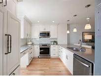 Well-lit kitchen featuring sleek stainless steel appliances and ample white cabinetry at 480 S Marion Pkwy # 306, Denver, CO 80209