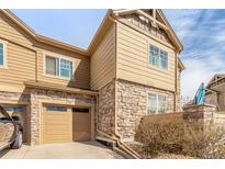 Charming two-story townhouse with a stone and wood facade, attached garage, and well-maintained landscaping at 5722 S Addison Way # A, Aurora, CO 80016