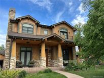 Charming two-story home with a stone chimney, covered porch, and inviting curb appeal at 2980 S Adams St, Denver, CO 80210