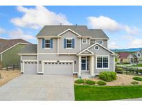 Charming two-story home featuring a three-car garage, and well-manicured lawn at 19316 W 84Th Pl, Arvada, CO 80007