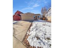 Ranch style home with attached two-car garage and snowy front yard at 4169 S Lewiston St, Aurora, CO 80013