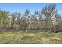 Scenic backyard featuring mature trees and lush lawn, creating a peaceful outdoor setting at 444 Vance St, Lakewood, CO 80226
