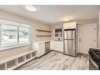Bright kitchen features stainless steel appliances, white cabinetry and granite countertops at 970 Lima St, Aurora, CO 80010