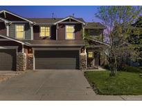 Charming townhome featuring a two-car garage, stone accents, and a well-maintained lawn at 5786 Raleigh Cir, Castle Rock, CO 80104