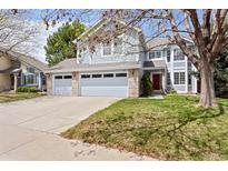 Charming two-story home features a three-car garage, well-maintained lawn, and inviting red door at 9745 Quay Loop, Westminster, CO 80021