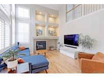 Bright living room with vaulted ceilings, fireplace, and hardwood floors at 360 Peregrine Cir, Broomfield, CO 80020