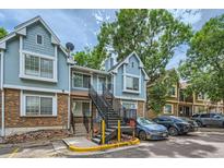 Charming two-story condo with light blue siding, brick accents, and convenient parking at 63 S Sable Blvd # E22, Aurora, CO 80012