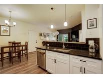 Bright kitchen featuring a black granite countertop, stainless steel appliances and a dining area at 2430 W 82Nd Pl # 2F, Westminster, CO 80031
